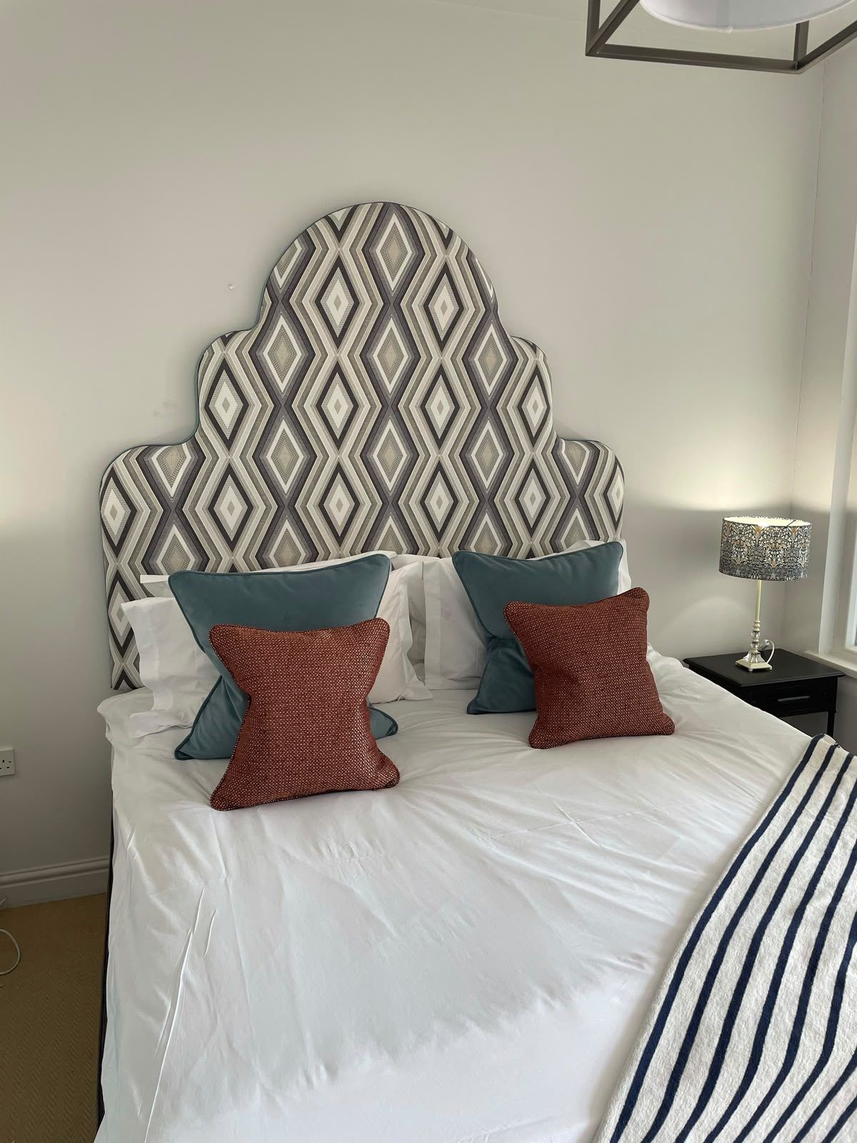A bespoke headboard in a woven medallion fabric